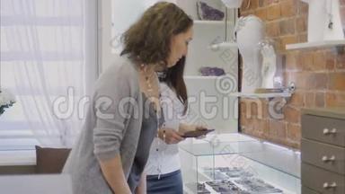 销售经理向珠宝店的女买家展示珠宝